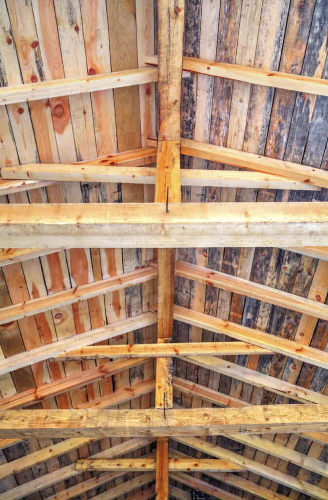 Les fermes de toit en bois, rappelant la charpente à Souillac, présentent diverses nuances et textures de bois, fournissant un support structurel essentiel dans un bâtiment.
